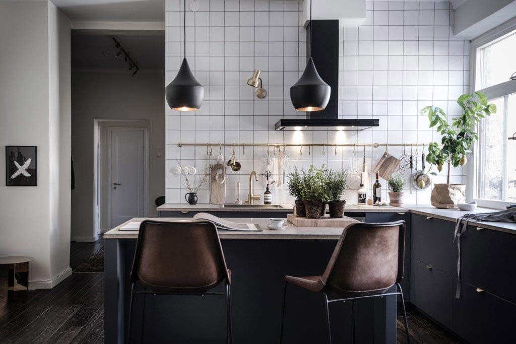 Voor deze stoere keuken is de keuken achterwand tot aan het plafond betegeld met minimalistische witte vierkante tegels.