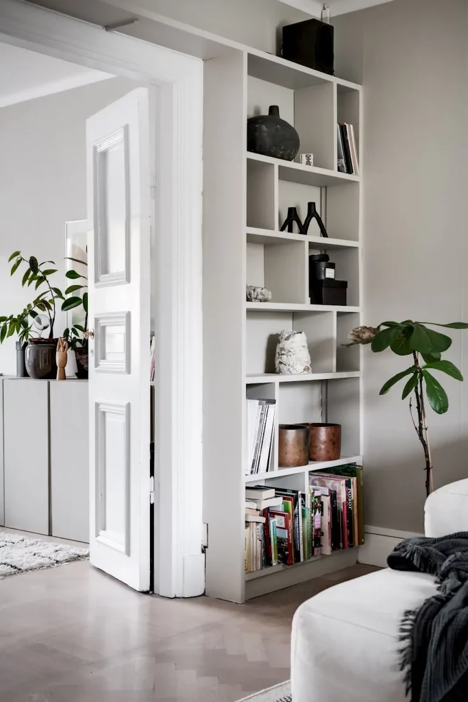 minimalistische boekenkast zelfde kleur als muur