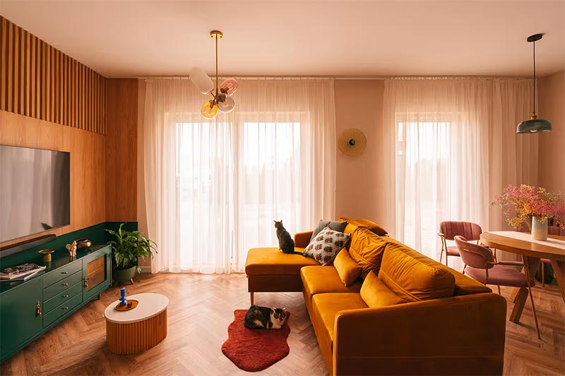 Een visgraat houten vloer kan er na een behandelbeurt weer als nieuw uitzien. Deze moderne vintage woonkamer is ontworpen door Wojtyczka Pracownia Projektowa.